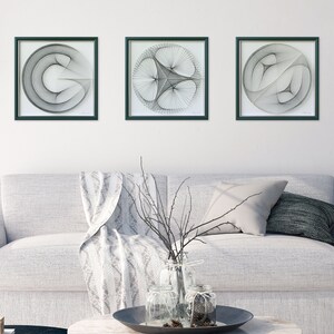 Puede incluir: Tres piezas de arte de hilo en blanco y negro enmarcadas con dise&ntilde;os geom&eacute;tricos. Los marcos son de color verde oscuro y el fondo es blanco.