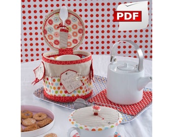 May include: A set of tea time accessories, including a tea cozy, a teacup with a lid, a teapot, and a cookie jar. The tea cozy is made of fabric with a polka dot pattern and the text "Enjoy your tea time". The teacup and teapot are white ceramic. The cookie jar is made of fabric with a polka dot pattern and has a spoon inside. The accessories are on a white table with a red and white polka dot tablecloth.