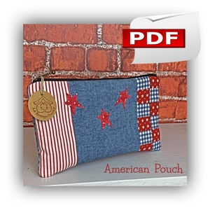 Puede incluir: Una bolsa de tela roja, blanca y azul con estrellas y una cremallera. La bolsa está etiquetada como "American Pouch".
