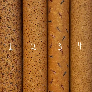 Può includere: Quattro rotoli di tessuto con motivi diversi. Il tessuto è di colore marrone chiaro con una varietà di motivi in rosso, blu e nero. Il tessuto è numerato da 1 a 4.