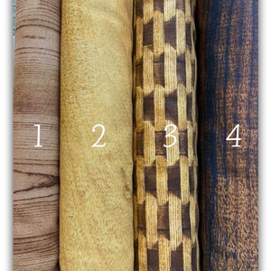 Può includere: Quattro campioni di tessuto in diversi motivi a venatura del legno. Il primo campione è una venatura del legno marrone, il secondo è una venatura del legno marrone chiaro, il terzo è un motivo a scacchi marrone e beige, e il quarto è una venatura del legno marrone scuro.