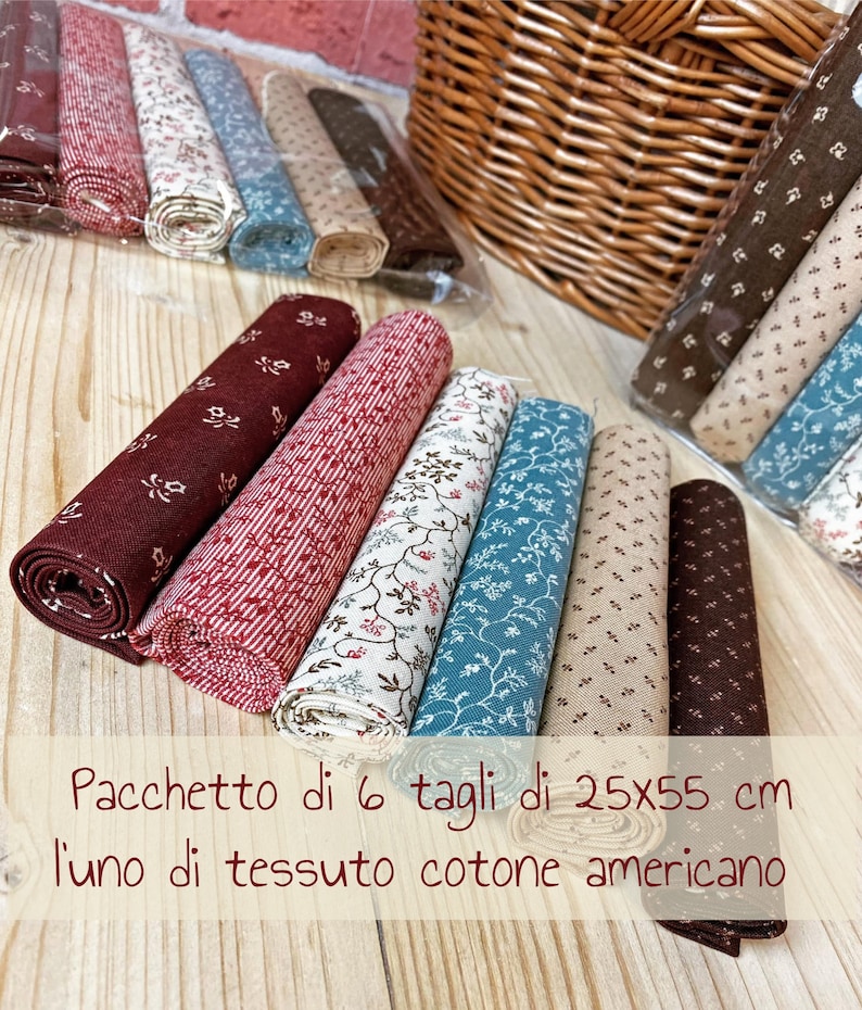 Pode incluir: Um pacote de seis cortes de tecido, cada um medindo 25x55 cm, feito de algod&atilde;o americano. O tecido est&aacute; enrolado e apresenta v&aacute;rios padr&otilde;es florais em tons de vermelho, marrom, bege e azul.