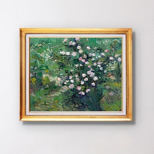 Può includere: Un dipinto incorniciato di un roseto bianco in fiore. Il roseto è circondato da fogliame verde e lo sfondo è un cielo azzurro chiaro. Il dipinto è in una cornice dorata.