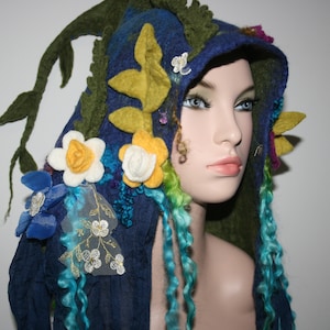 May include: A blue hooded hat with felt flowers, leaves, and vines. The hat has long, curly blue and green yarn strands hanging from the bottom.