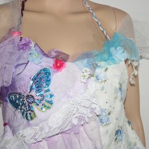 May include: A purple and white dress with a butterfly design, floral embellishments, and lace trim.