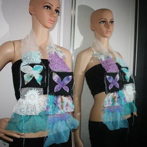 Könnte beinhalten: Ein mehrlagiger Schal mit einer weißen Basis und verschiedenen Blautönen und Lila-Stoffen. Der Schal hat mehrere Schmetterlingsapplikationen und einen Spitzenbesatz.