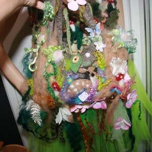 Könnte beinhalten: Eine grüne, braune und rosafarbene Filztasche mit einem Reh, Blumen und Blättern. Die Tasche ist mit verschiedenen Texturen und Farben verziert.