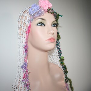 May include: A white crocheted hat with pink, purple, and green yarn accents. The hat has a floral design with small crocheted flowers.