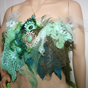 May include: A green and brown lace top with a floral design. The top is made of several layers of lace and fabric, and it has a delicate, feminine look.