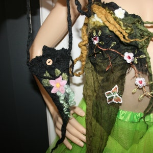 Può includere: Un top in tessuto felpato nero e verde con ricami floreali e una borsa in tessuto felpato nero abbinata con un design floreale.
