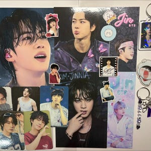 Peut inclure: Une collection de produits dérivés de Jin de BTS comprenant plusieurs tirages photo brillants, des petites cartes portrait et trois porte-clés. Les articles présentent divers portraits photographiques de l'artiste, des autocollants de personnages et du texte dont Jin BTS et RJ.