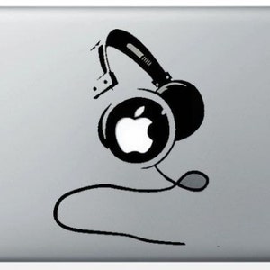 Può includere: Un adesivo in bianco e nero di cuffie con un logo Apple bianco al centro del padiglione auricolare. L'adesivo è su un laptop argentato.