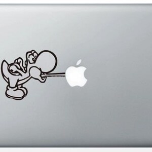 Può includere: Un adesivo in bianco e nero di un personaggio dei cartoni animati che soffia aria su un logo Apple su un laptop argentato.