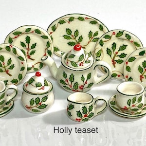 May include: A miniature holly tea set with a teapot, creamer, sugar bowl, two cups and saucers, and three plates. The set is decorated with green holly leaves and red berries.