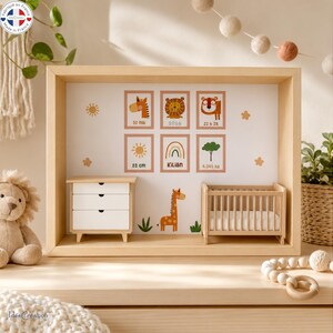Peut inclure: Une vitrine en bois clair avec un fond blanc orné de six illustrations encadrées représentant une girafe, un lion, un tigre, un soleil, un arc-en-ciel et un arbre. À l'intérieur se trouvent une commode miniature et un petit berceau en bois.