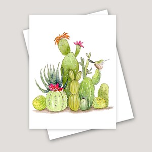 May include: Watercolor illustration of various cacti with green, yellow, and red hues. A small hummingbird perches on a cactus. The artwork is on a white card, with a second card partially visible behind it.