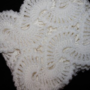 May include: White crocheted lace fabric with a delicate floral pattern. The fabric is soft and airy, and it would be perfect for a variety of crafting projects.