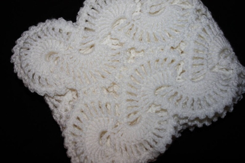May include: White crocheted lace fabric with a delicate floral pattern. The fabric is soft and airy, and it would be perfect for a variety of crafting projects.