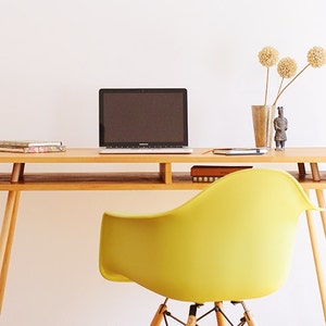 Office desk with solid wood legs and top made of beech wood, coated with natural yellowish color with a notebook and a diary on top of it