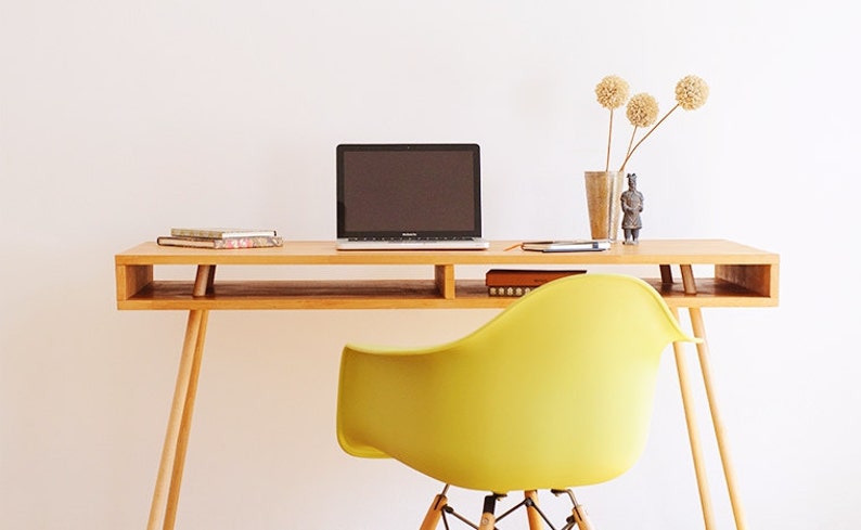 Office desk with solid wood legs and top made of beech wood, coated with natural yellowish color with a notebook and a diary on top of it