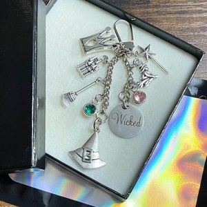 WICKED Musical Film Inspiriert Schlüsselanhänger Charm Set Anhänger Strass Krone Hexenhut Besen Zauberstab Schloss Charm Andenken Box Tasche
