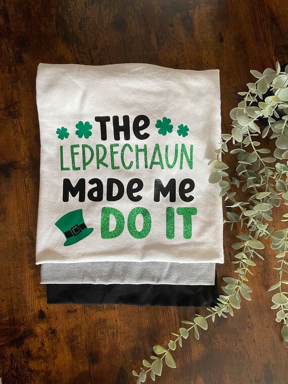 St Patrick’s Day Vinyl Printed T-Shirt The LEPRECHAUN Made Me Do It Shamrocks Clover Hat Glitter Fun Novelty Irish Ireland Gift Quirky Green