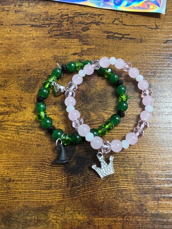 Wicked Film Inspired Two Magnetic Bracelets Witches Hat Crown Charms Beaded Green Pink Elastic Magnetic Hearts To Attach Them Together Gift