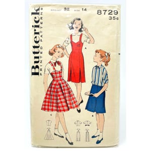 May include: Vintage Butterick printed patterns envelope featuring illustrations of girls' dresses. The envelope shows three girls in different outfits, including a red plaid dress, a red jumper, and a blue skirt with a striped shirt. The envelope has text that reads "Butterick Printed Patterns".