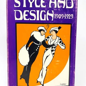 May include: A vintage book titled "STYLE AND DESIGN 1909-1929" with a purple cover. The cover features an orange square with an illustration of two women in black and white outfits. The author's name, Giulia Veronesi, is at the bottom.