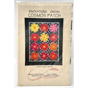 May include: A quilt pattern titled "Cosmos Patch" by Innovations. The pattern features a colorful floral design with red, yellow, and pink flowers on a black and white background. The approximate size is 59" x 74".