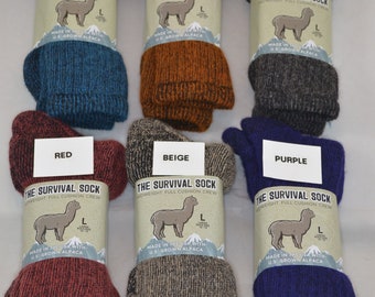 May include: Six pairs of alpaca wool socks in different colors: blue, copper, dark gray, red, beige, and purple. Each sock is labeled "The Survival Sock" with a picture of an alpaca and the text "Made in the USA with U.S. Grown Alpaca".