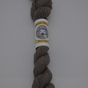 May include: A skein of gray alpaca yarn with a label that reads "Meadows Alpaca" and "Mack's Yarn".