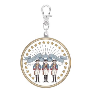 May include: A round, patriotic charm with a silver clasp. The charm features three colonial soldiers, a banner reading "UNITED WE STAND," and the date "July 1st 1776." Gold stars and a gold border complete the design.
