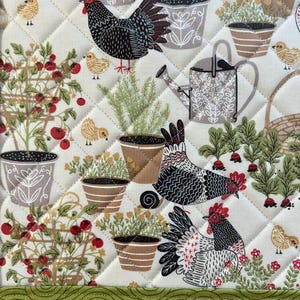Pu&ograve; includere: Un tessuto trapuntato a tema giardino. Il design presenta polli, piante in vaso, pomodori e un annaffiatoio. La tavolozza dei colori comprende crema, verde, rosso, marrone e nero. Il tessuto viene probabilmente utilizzato per la cucina o l'arredamento della casa.