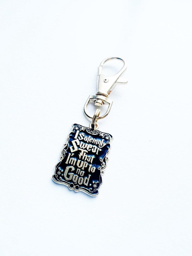 May include: A rectangular keychain with the text "I solemnly swear that I'm up to no good." The keychain has a black background with silver lettering and a silver clasp.