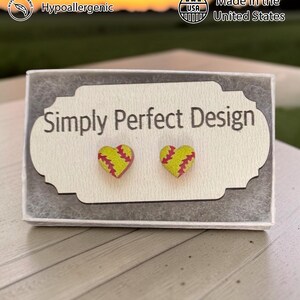 Softball heart studs on a card in a gift box at sunset