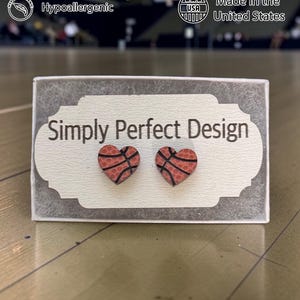 Basketball heart studs on a card in a gift box in a gym