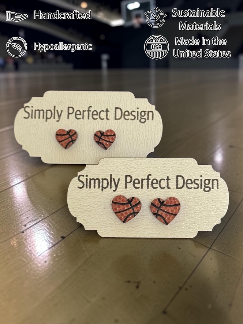Two sizes of basketball heart stud earrings on Simply Perfect Design cards in a gym