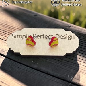 Softball heart studs on a card on a wood bench