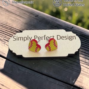 Softball heart stud earrings on a card outdoors