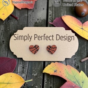 Heart shaped basketball studs on a card on a wood table with leaves