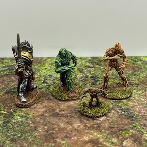 May include: Four miniature figures painted in a fantasy style. The figures are on circular bases with green grass. The figures are a warrior in silver armor, a green tree creature, a brown tree creature, and a smaller brown tree creature.