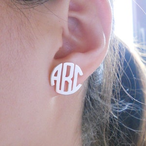 Puede incluir: Pendientes de plata con monograma en forma de círculo con las letras "ABC".