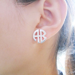 Puede incluir: Pendientes de plata con monograma en forma de círculo con las letras "AB".
