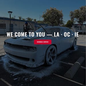 Puede incluir: Un coche deportivo oscuro cubierto de espesa espuma de jabón blanca durante un servicio de limpieza móvil. El texto superpuesto dice: Premium Auto Spa, We Come To You — LA · OC · IE y Schedule Service. La interfaz incluye enlaces.