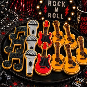 Pode incluir: Uma coleção de biscoitos com tema de rock and roll dispostos num prato preto. Os biscoitos têm a forma de notas musicais pretas com purpurina, microfones prateados, guitarras elétricas vermelhas e guitarras acústicas amarelas.