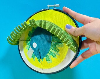 CAI |  fiber art sculpture of neon green and teal eye, one-of-a-kind design handmade by artist, quirky wall decor