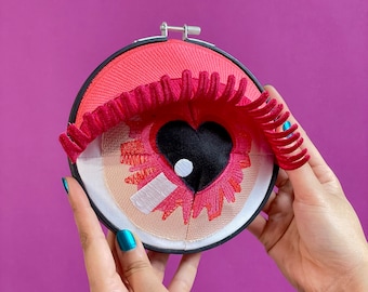 EYE HEART YOU |  Pink fiber art sculpture of eye with heart iris & pink eye lids, one-of-a-kind design handmade by artist, valentines decor