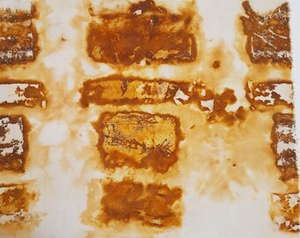 May include: A rectangular piece of off-white fabric featuring a repeating pattern of rust-colored, rectangular shapes. The design displays a distressed, weathered appearance with varying intensities of brown pigment and soft, blurred edges.