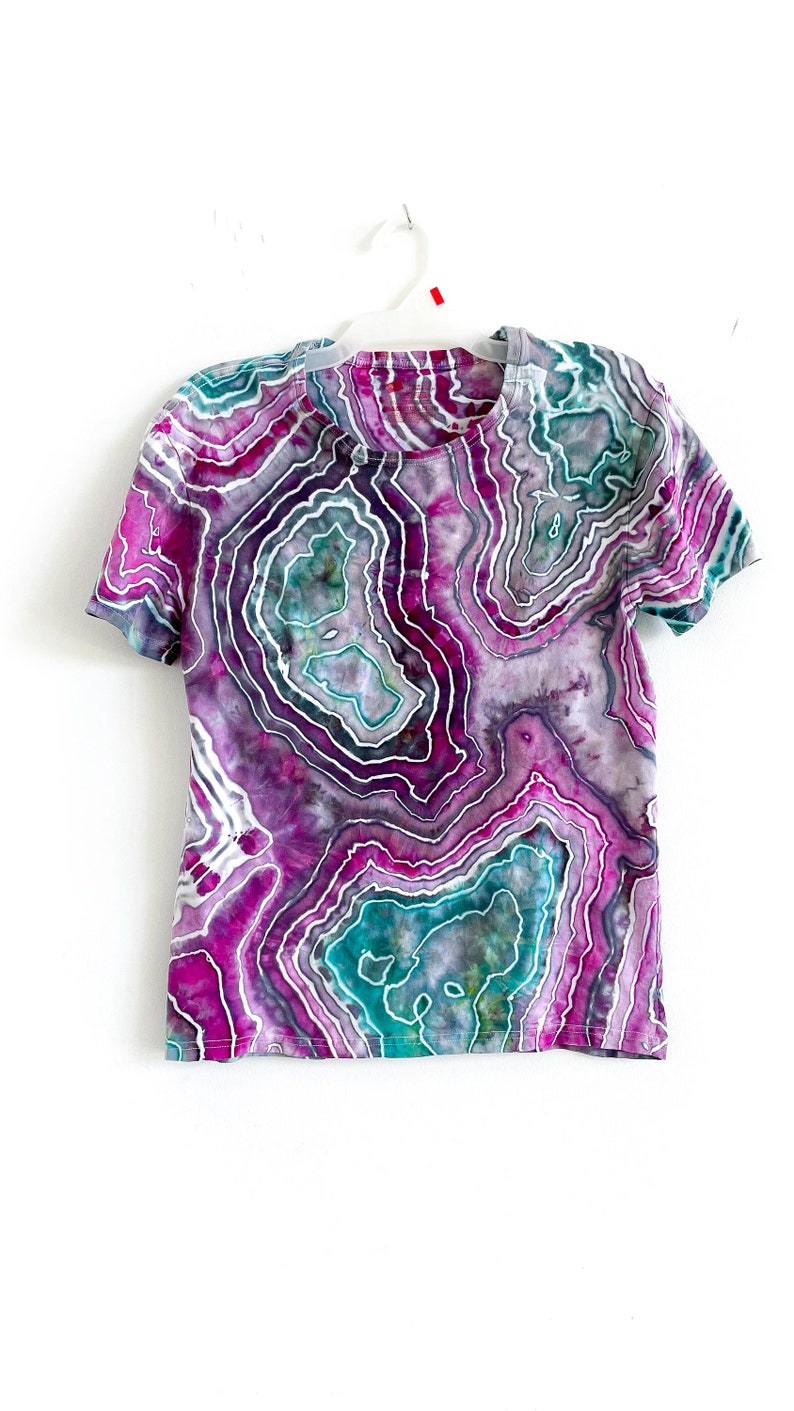 May include: A purple, teal, and gray tie-dye t-shirt with a swirling, agate-like pattern.
